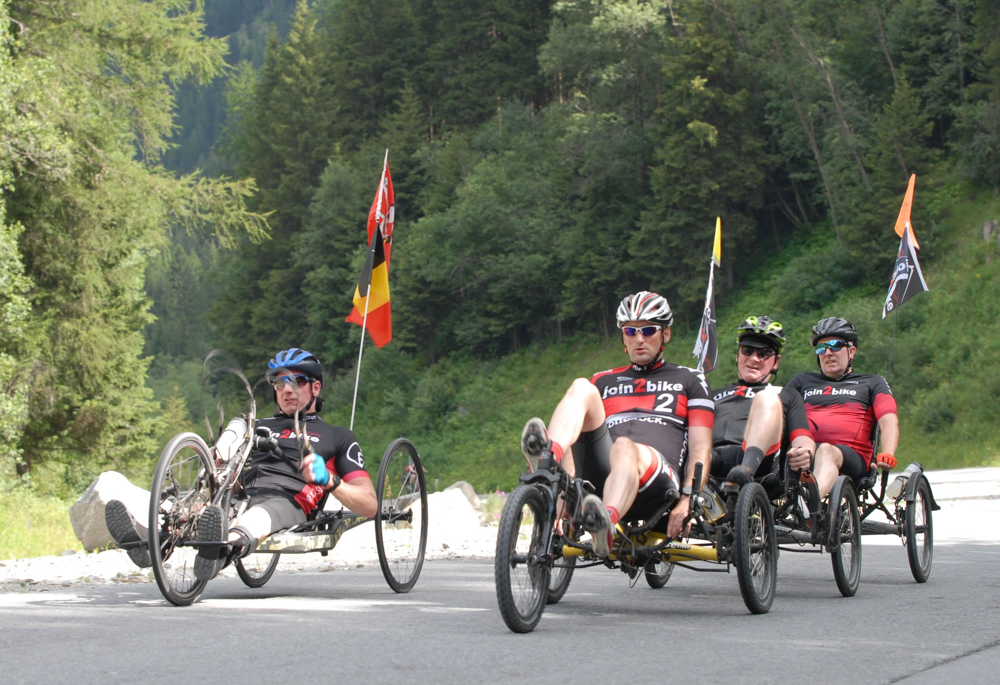 Een handbike en een treintje van drie gekoppelde trikes